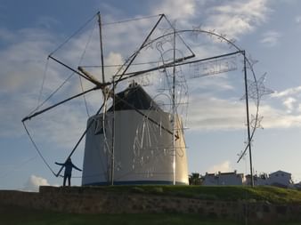 Eine Windmühle steht auf einer kleinen Anhebung auf der Wanderroute Rota Vicentina.